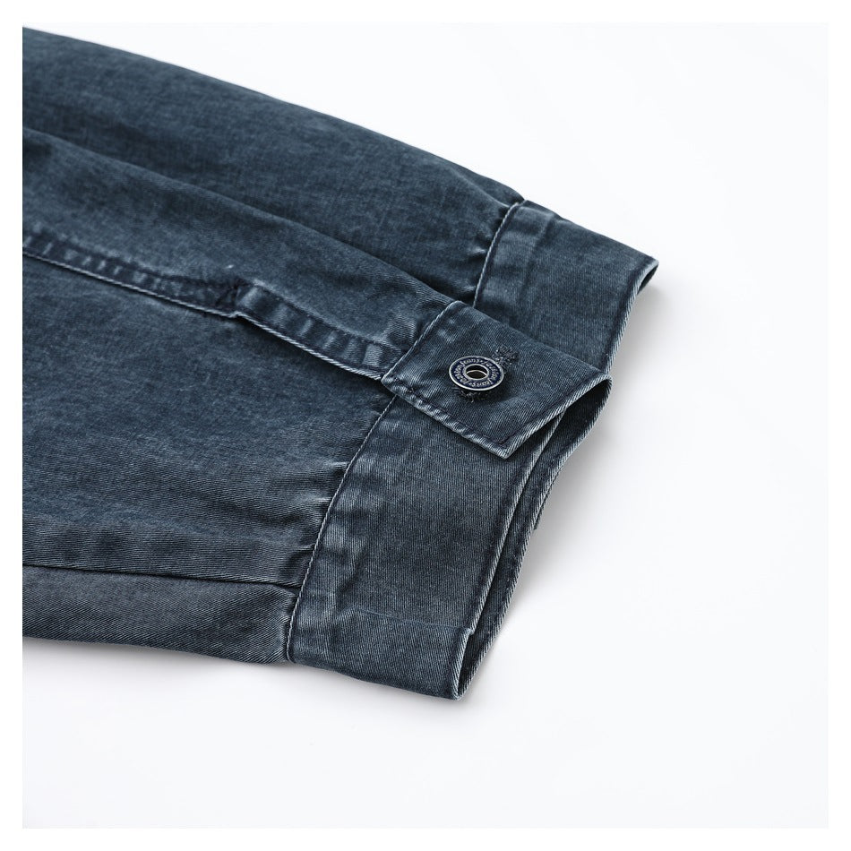 Close-up of a buttoned cuff and sleeve on a dark blue denim garment.