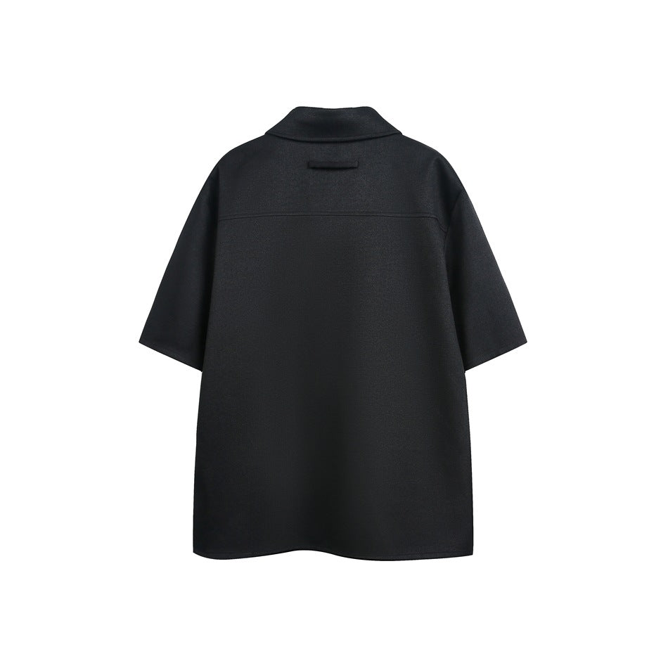 Back view of a black short-sleeve collared shirt with a horizontal back yoke seam.