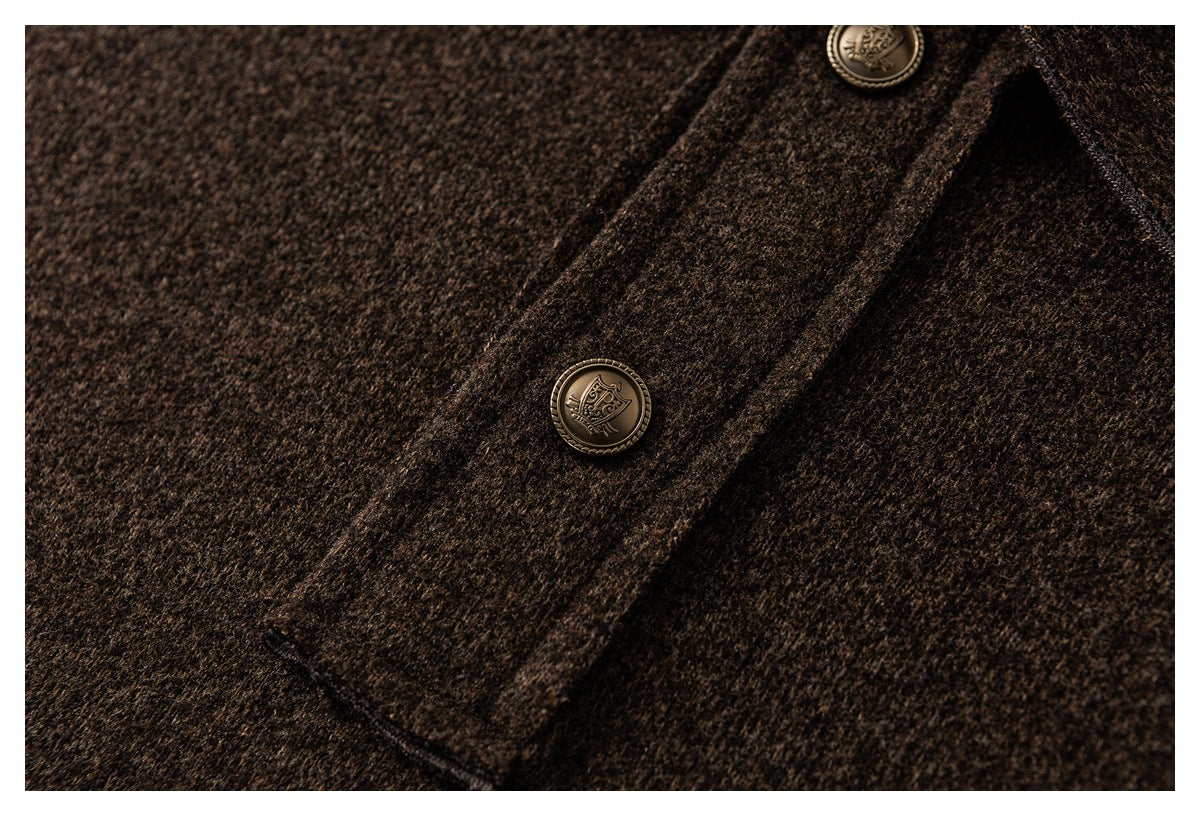 Close-up of a dark brown jacket placket with two ornate brass-tone buttons and a stitched pocket edge.