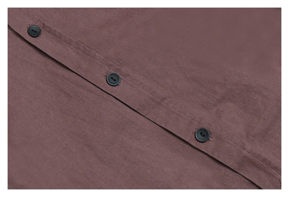 Close-up of dusty mauve-brown fabric with a diagonal button placket and three dark buttons.