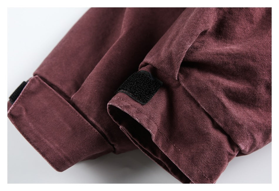 Close-up of a burgundy jacket cuff with a black hook-and-loop tab.