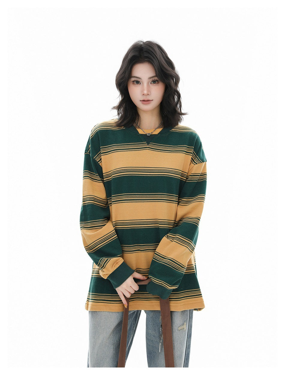 Front view of a model wearing an oversized green and mustard striped long-sleeve shirt with jeans.