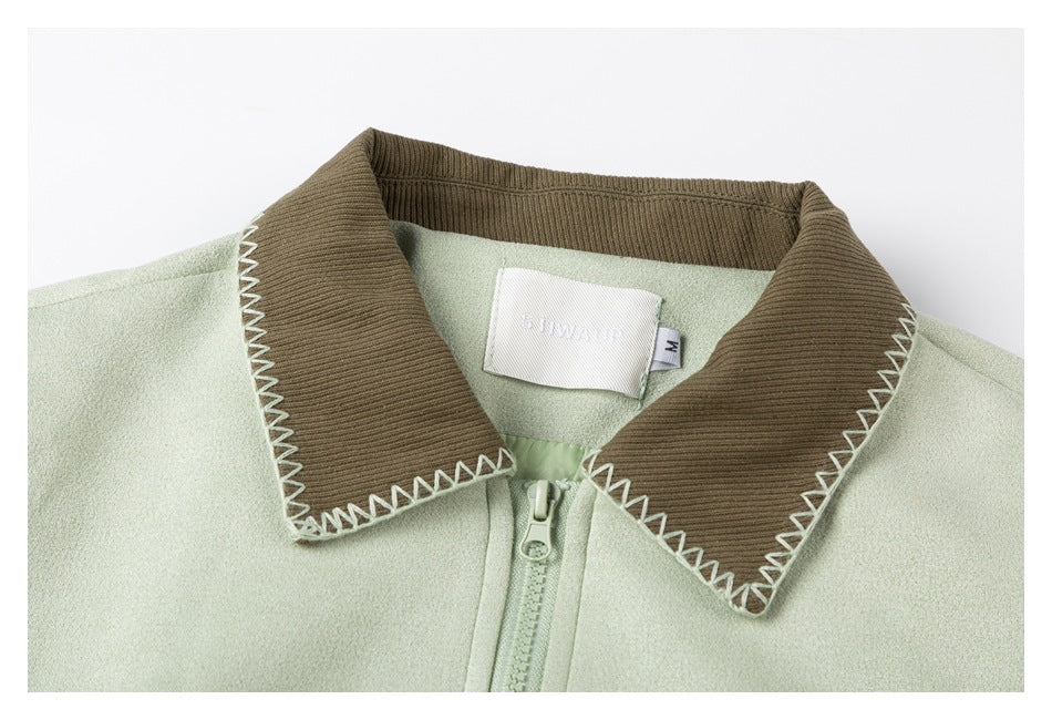 Close-up of the jacket's brown ribbed collar with white zigzag stitching, zipper, and inner neck label.
