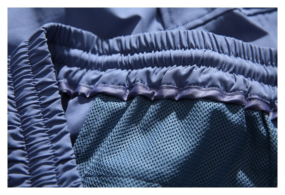 Close-up of the gathered waistband and dark mesh lining inside blue shorts.