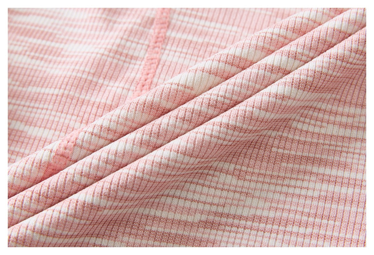 Macro view of pink-and-white ribbed striped fabric folded into soft diagonal ridges.