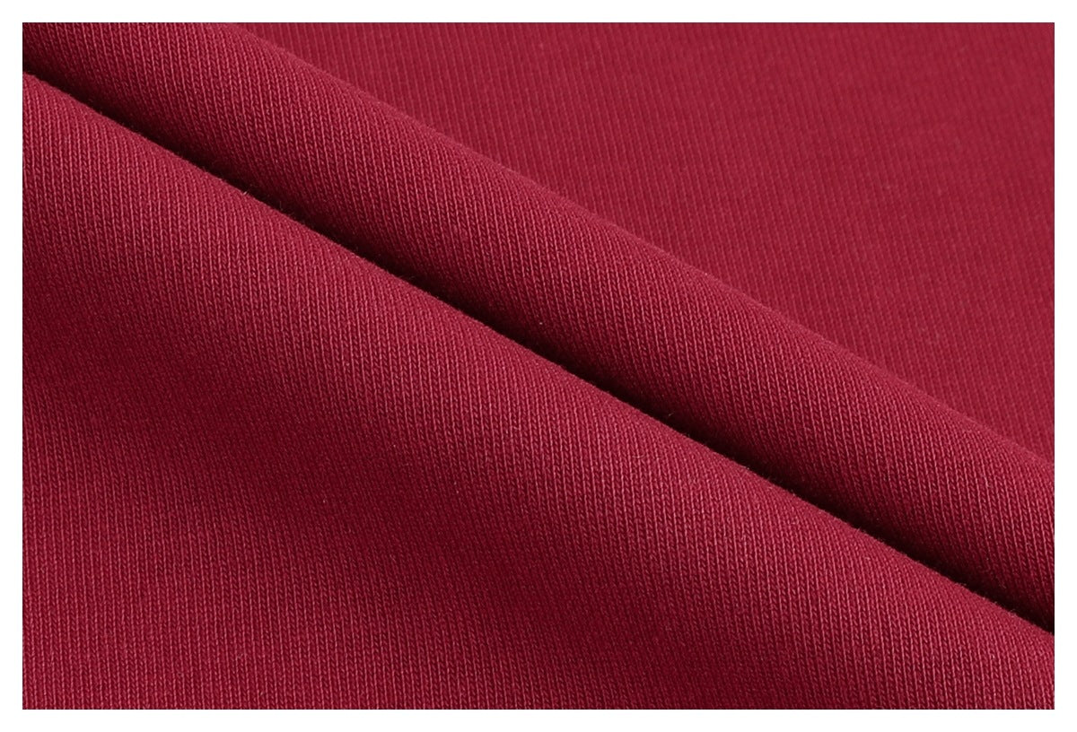 Macro view of burgundy knit fabric folded to show its surface and texture.