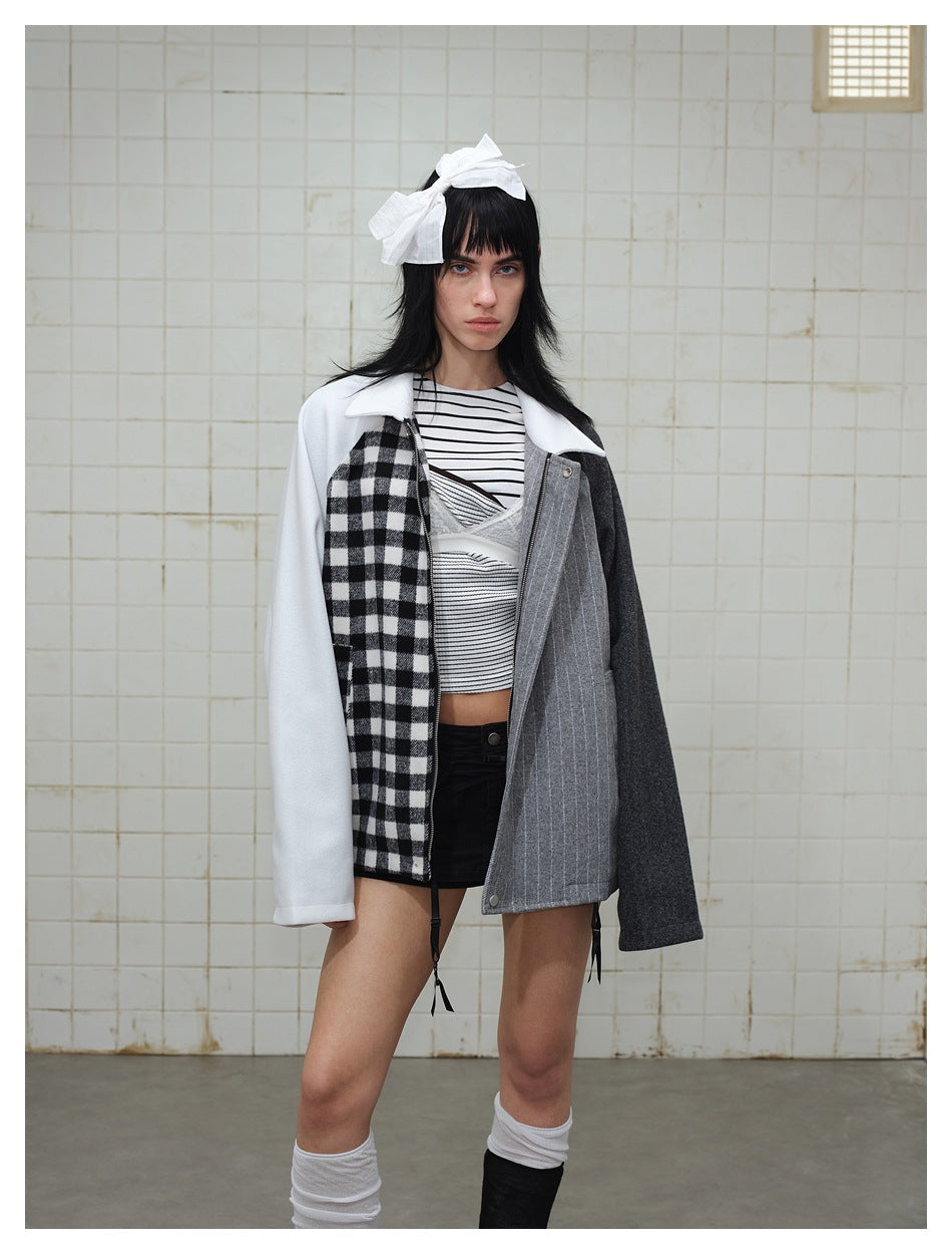 Model wearing a color-block jacket with a white sleeve, black-and-white check panel, gray pinstripe front, and charcoal