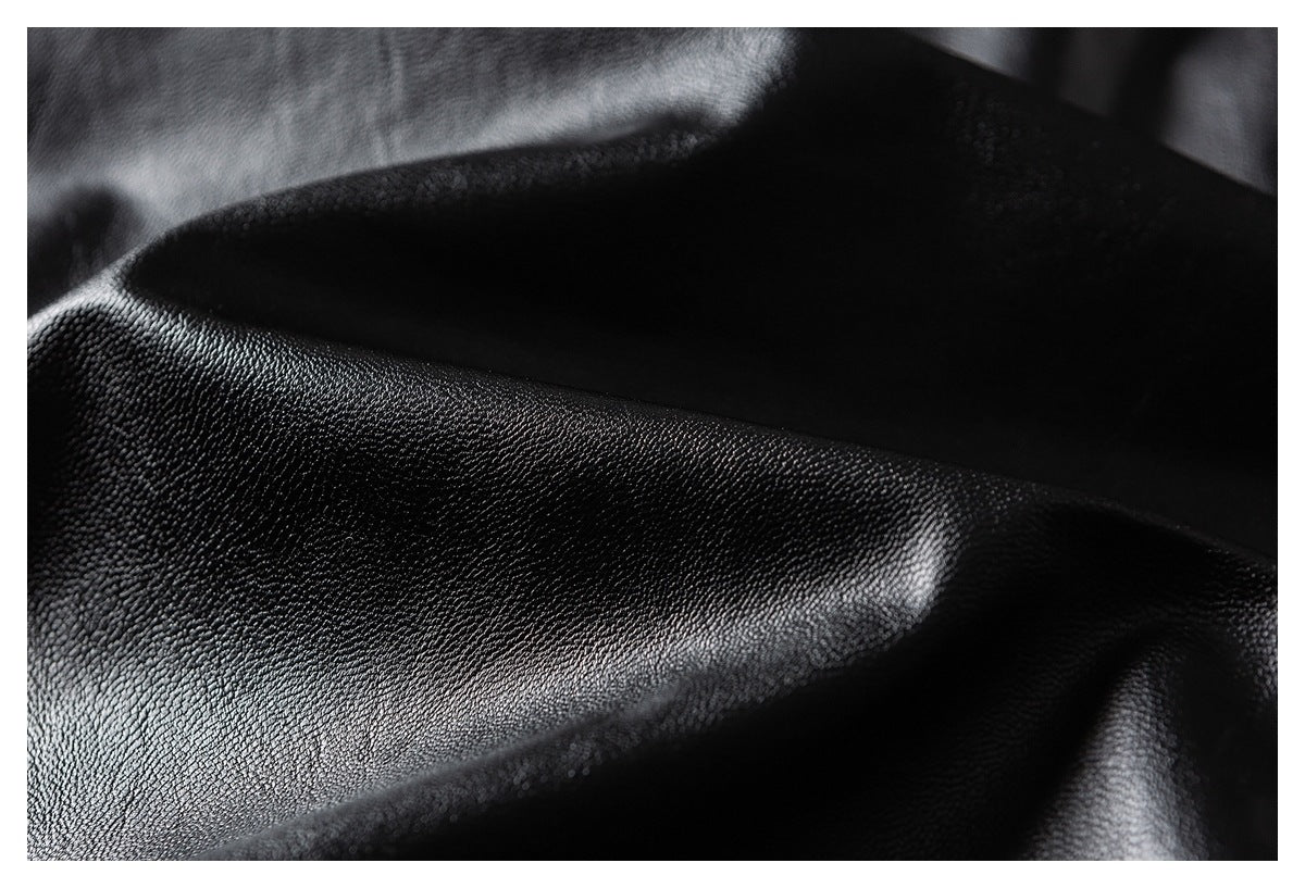 Close-up showing the glossy texture and folds of black garment material.