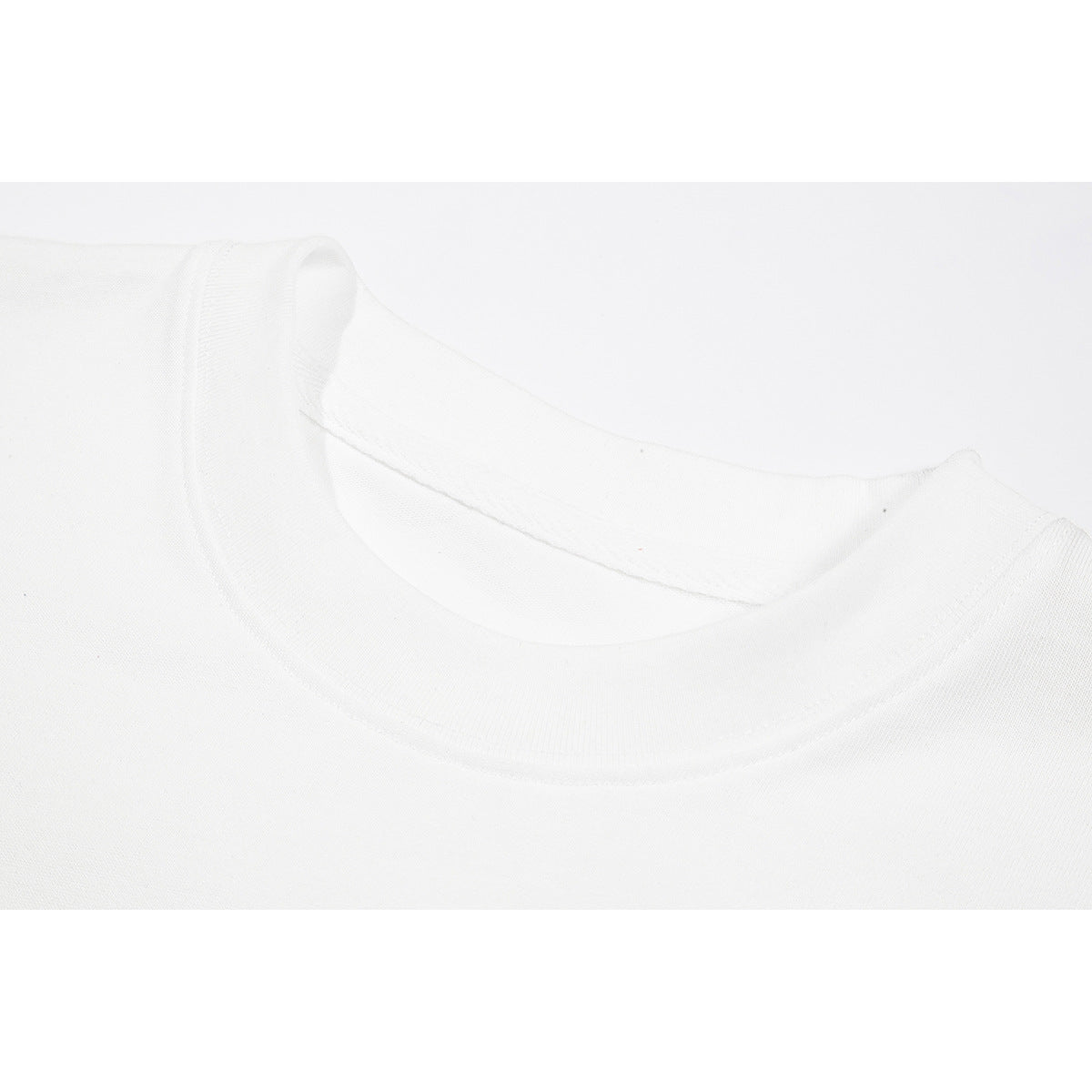 Close-up of the white T-shirt's ribbed crew neckline and stitching.