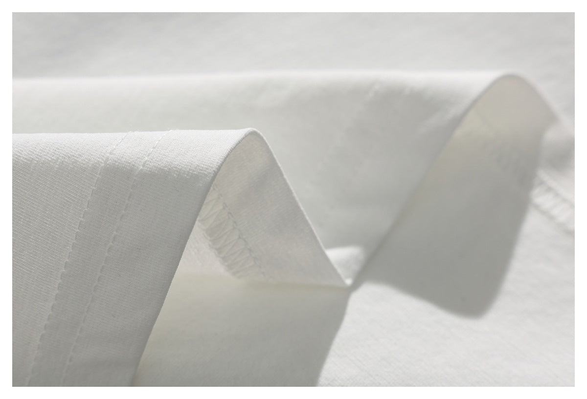 Close-up of a white garment edge with visible overlock stitching.