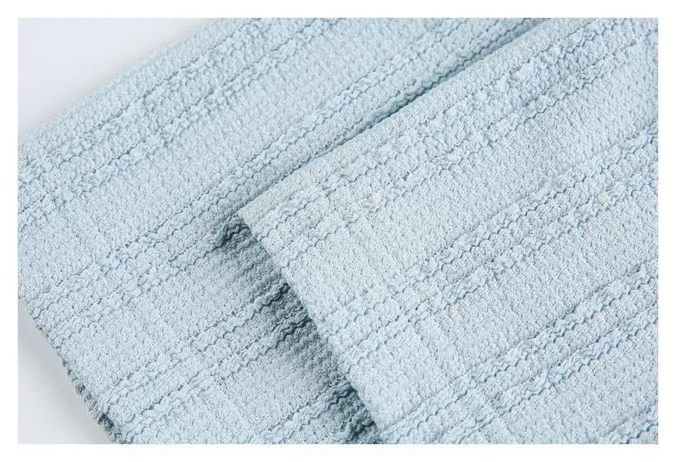 Close-up of overlapping sections of pale blue textured knit fabric.