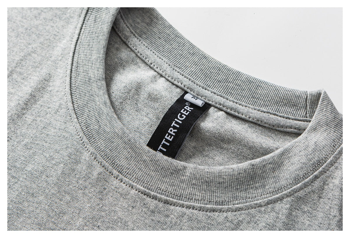 Close-up of a heather gray crewneck shirt collar with ribbed trim and a black neck label.