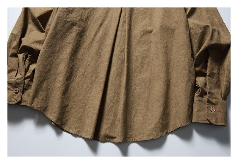 Close-up of a brown long-sleeve shirt showing its curved hem and buttoned cuffs.