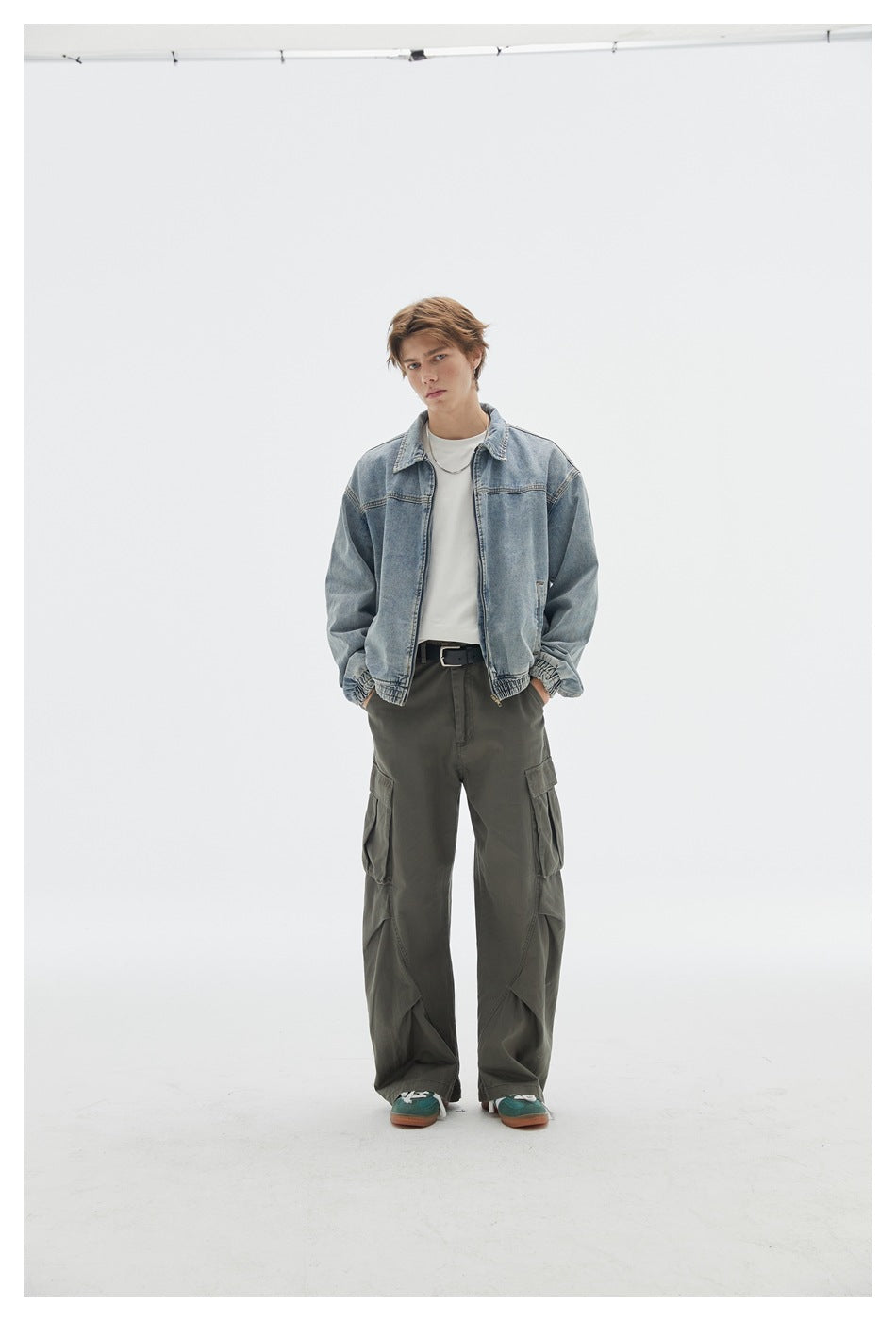 Front view of a model wearing a light blue zip-front denim jacket over a white shirt and olive cargo pants.