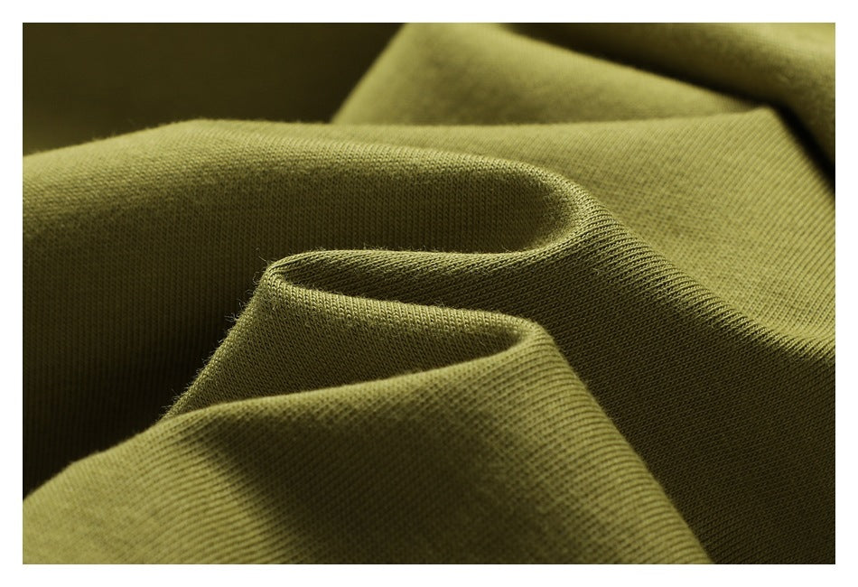 Macro view of folded olive-green fabric showing its knit texture.