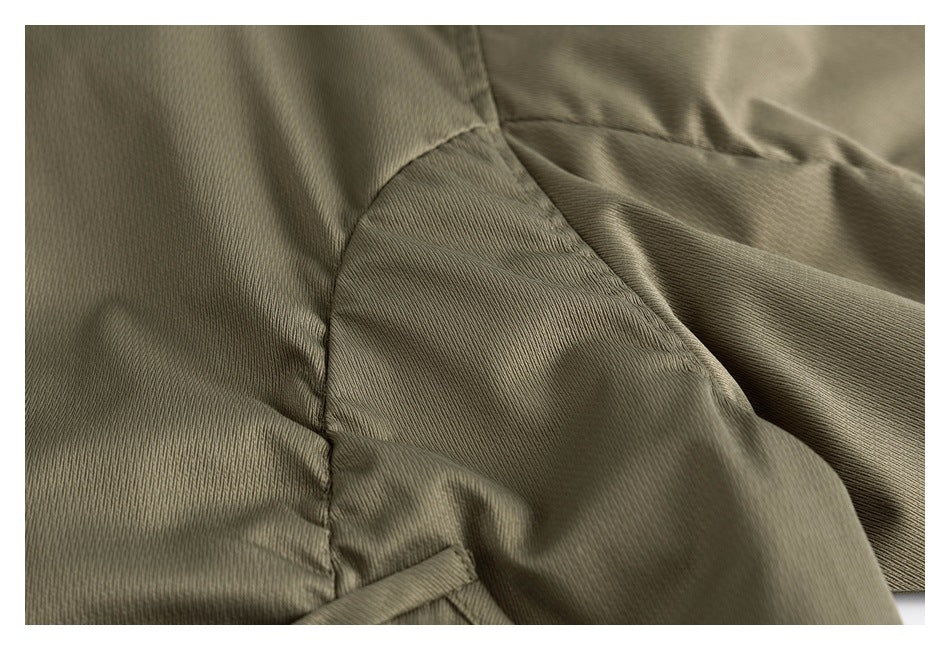 Close-up of olive garment fabric, showing a curved seam and adjoining panels.