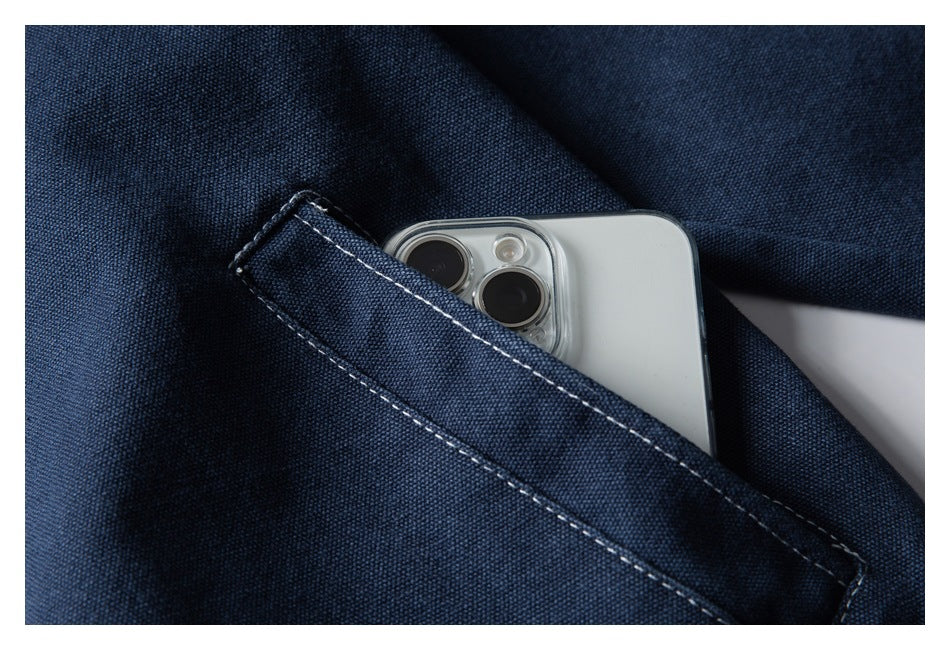A smartphone tucked into a stitched pocket on dark navy fabric.