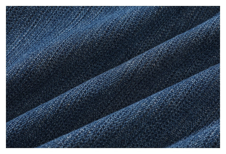 Extreme close-up of the textured weave of dark blue denim fabric.