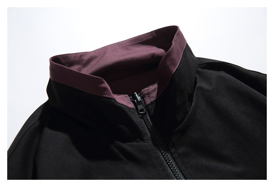 Close-up of the black jacket's plum-lined stand collar and front zipper.