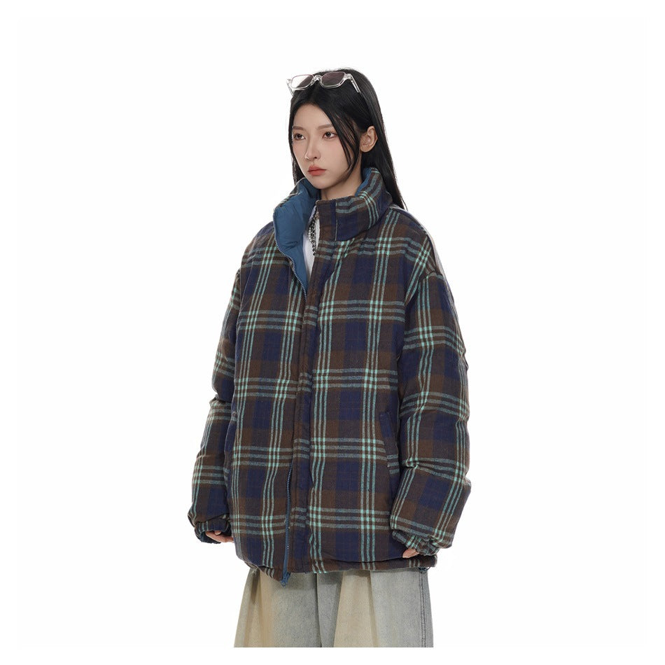 Model wearing a brown, navy and teal plaid puffer jacket with a contrasting blue inner collar.