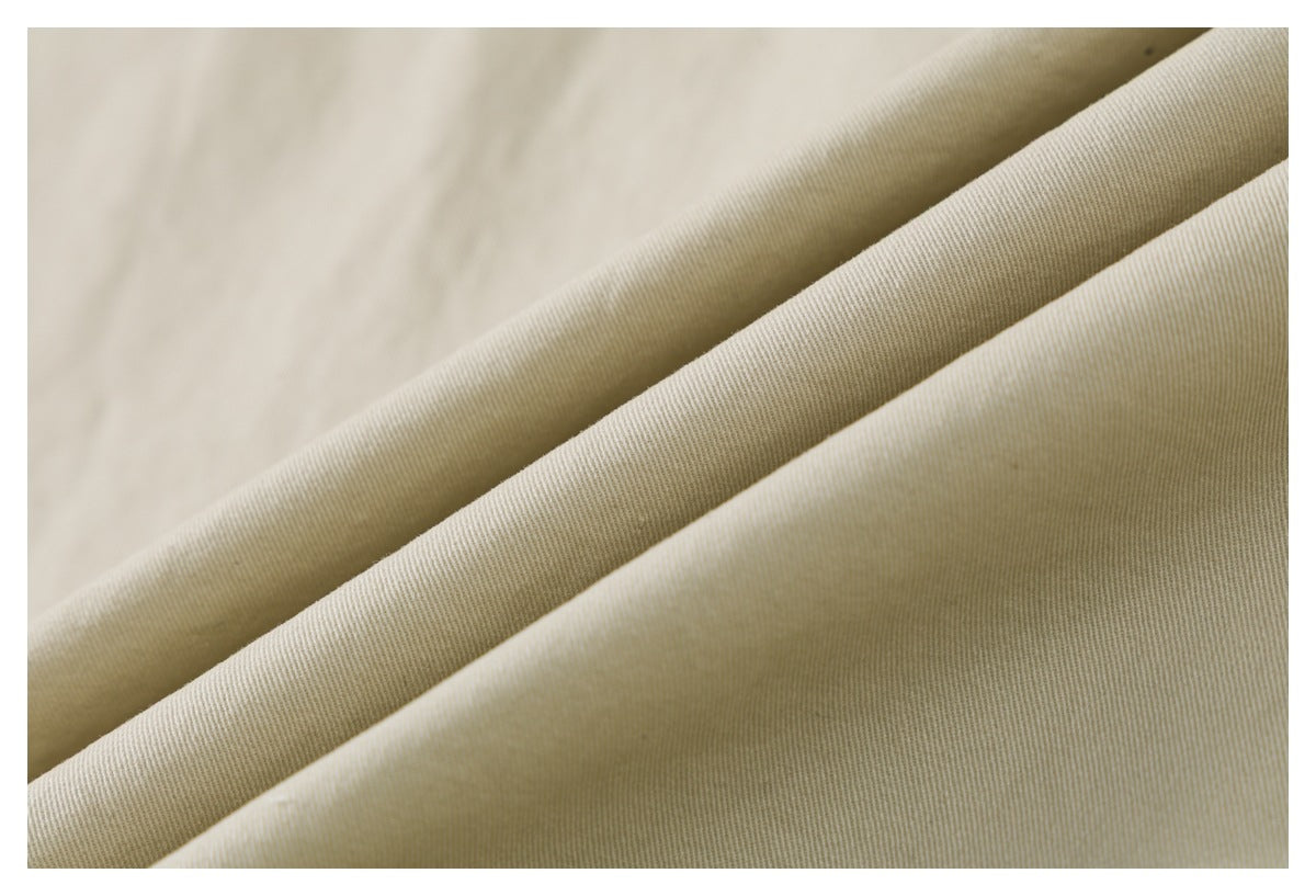 Macro view of beige shirt fabric folded to show its fine diagonal weave.