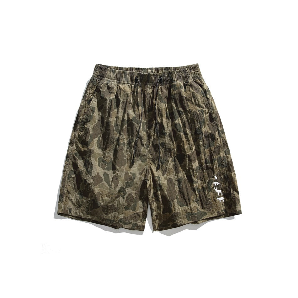 Olive green duck-hunter camouflage shorts with drawstring waist and white animal motif at the lower leg, flat front view
