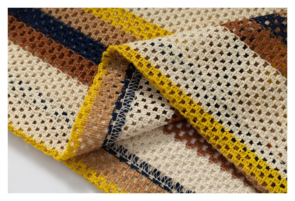 Close-up of the striped open-knit garment folded back to show its mustard edge and interior stitching.