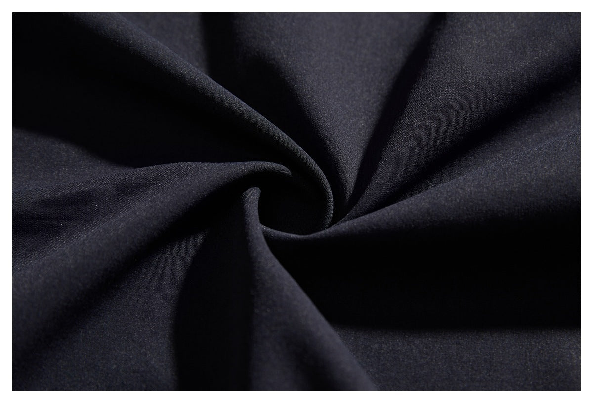 Close-up of dark fabric arranged in folds, showing a fine, even surface texture.