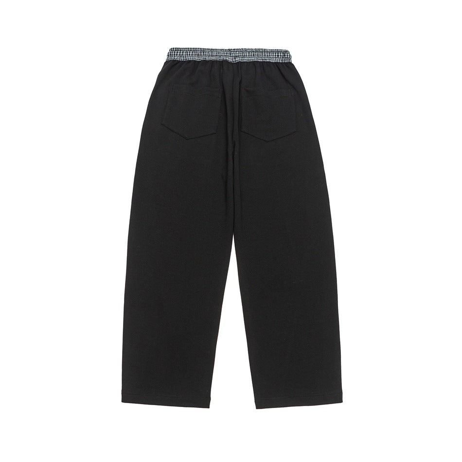 Back view of black wide-leg pants with two rear pockets and a checked waistband.