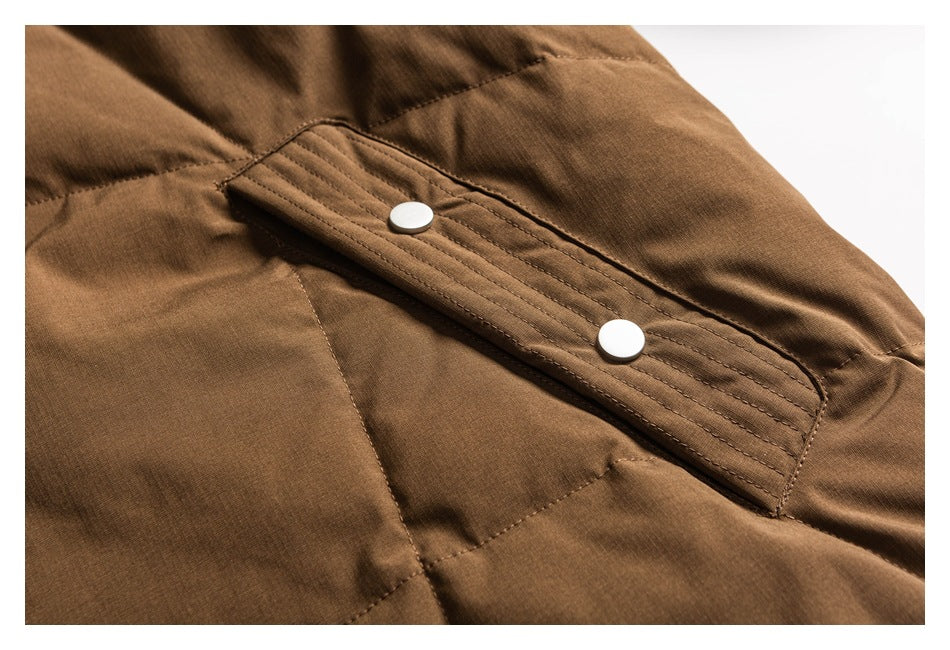 Close-up of a brown jacket pocket flap with two round white snap buttons.
