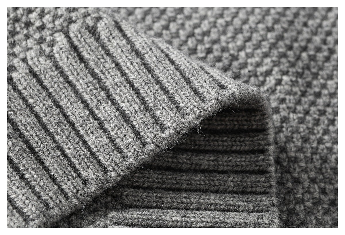 Macro view of gray knit fabric and layered ribbed sweater edges.