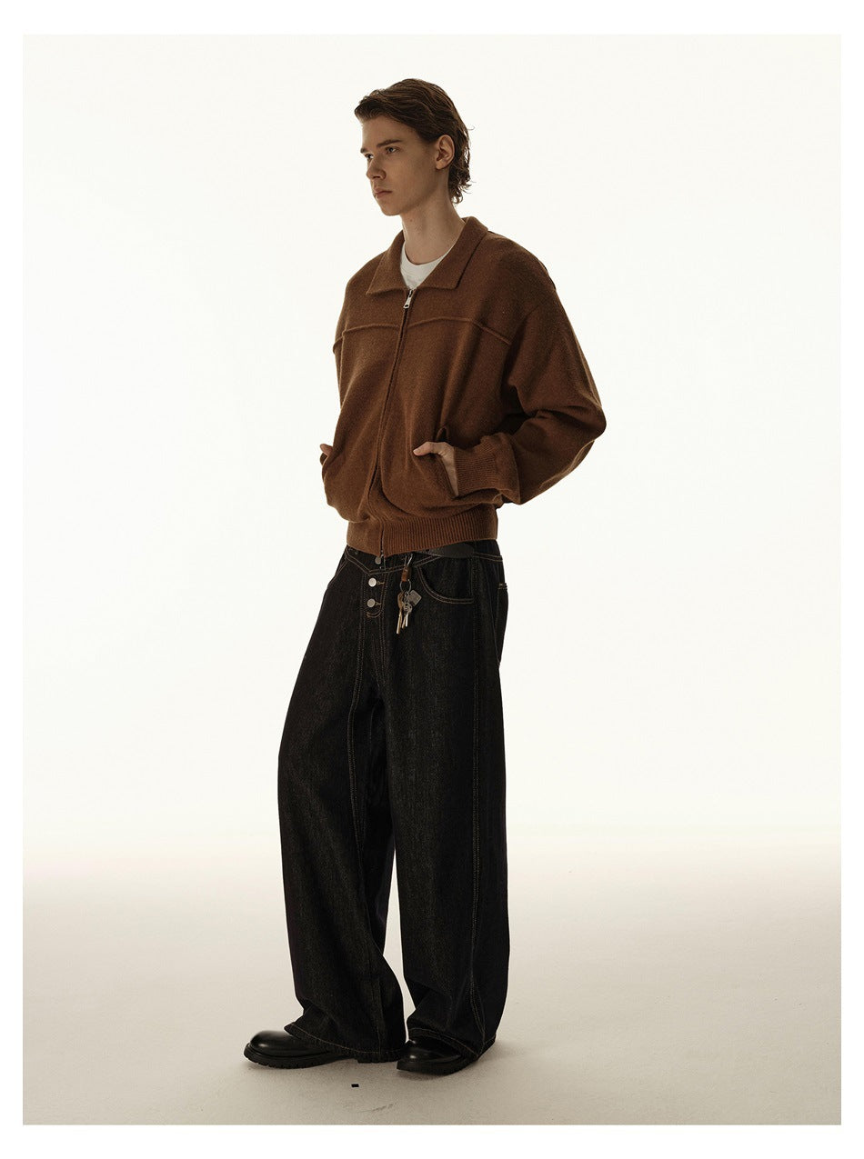 Model wearing a brown zip-front jacket with a pointed collar and dark wide-leg jeans, angled view.