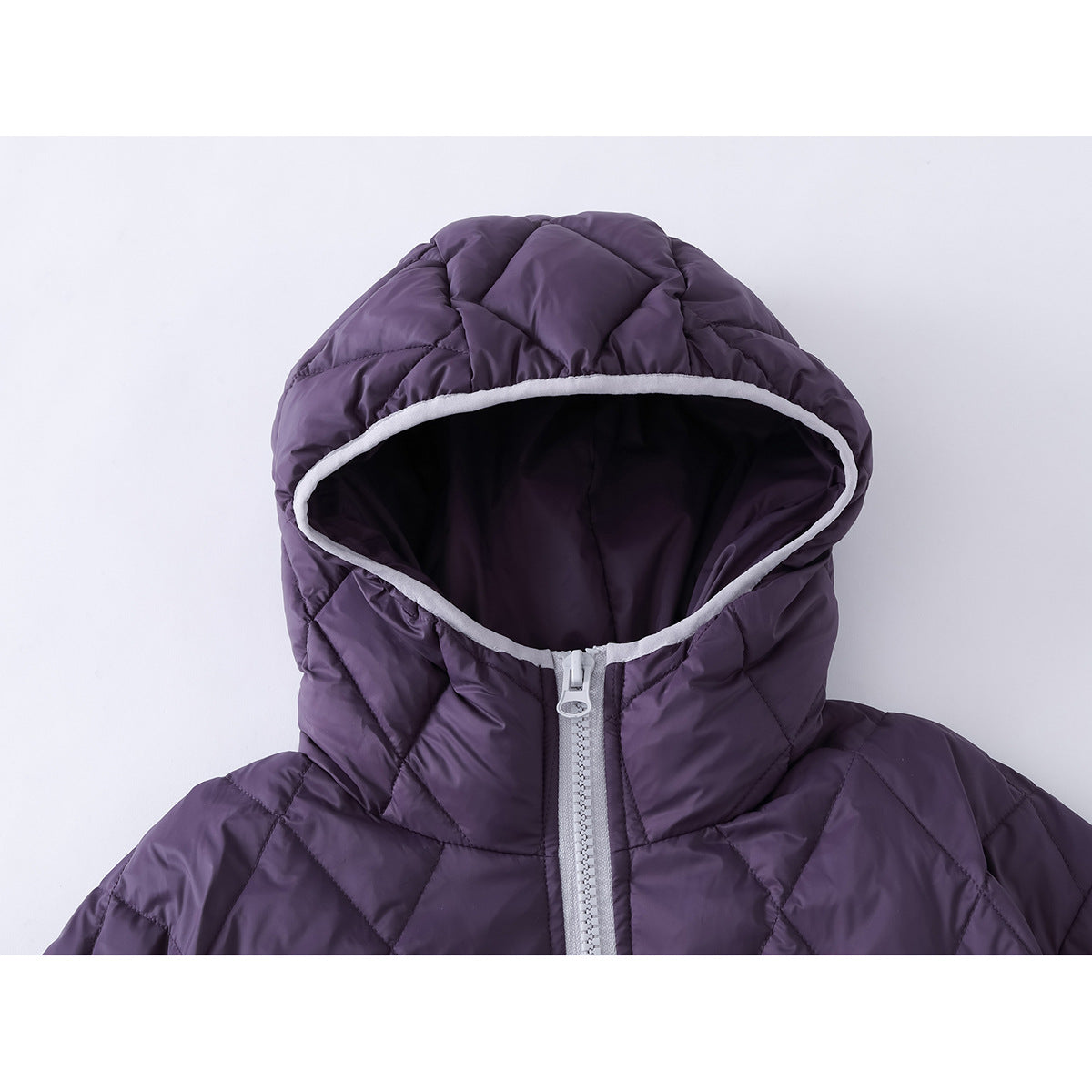 Close-up of a purple quilted jacket hood with pale trim and a light-colored front zipper.