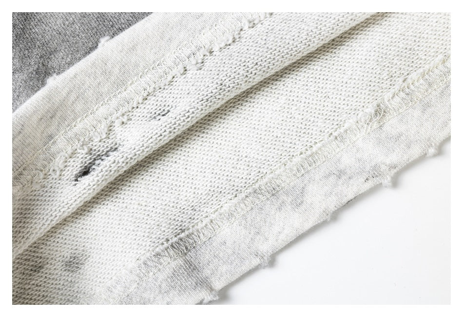 Close-up of the inside knit fabric and overlocked seam of light gray shorts.