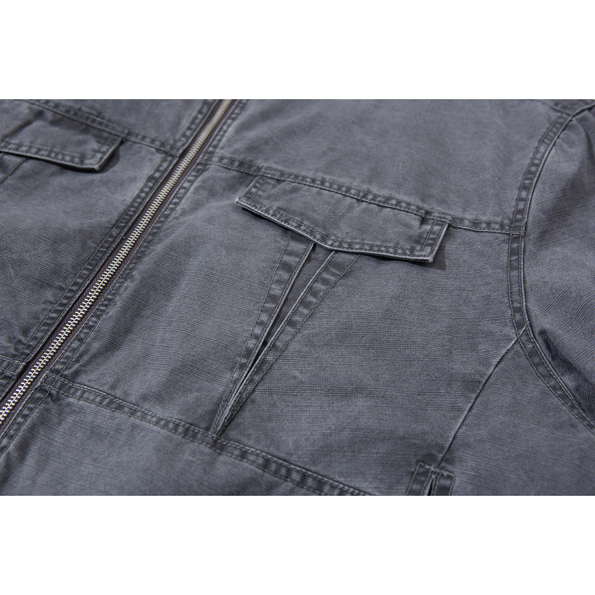 Close-up of a charcoal-gray jacket’s zip front and flap chest pocket.