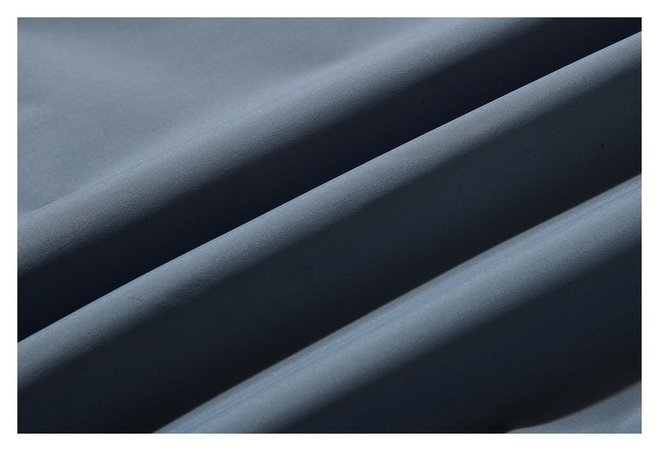 Close-up of smooth gray-blue garment fabric arranged in soft folds.