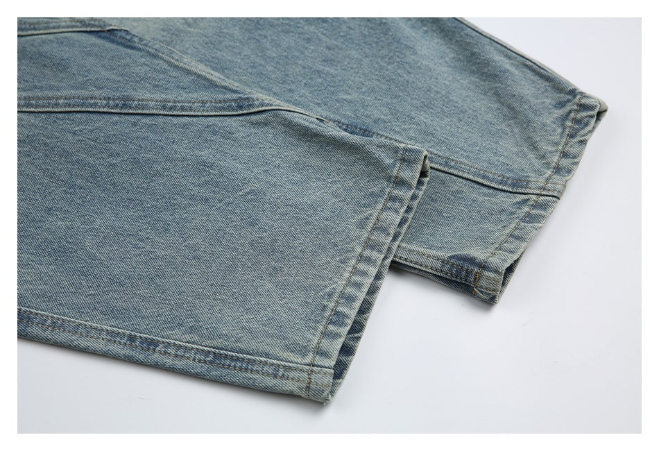 Close-up of light blue washed jeans showing the stitched leg hem and folded fabric edge.