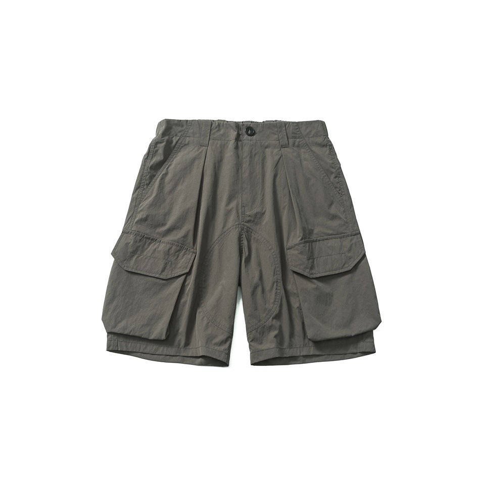 Gray-green cargo shorts with large flap thigh pockets and a button front, flat lay, front view