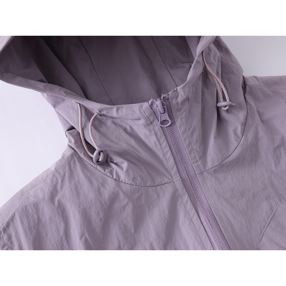 Close-up of the lavender vest's hood, drawcord adjusters and front zipper.