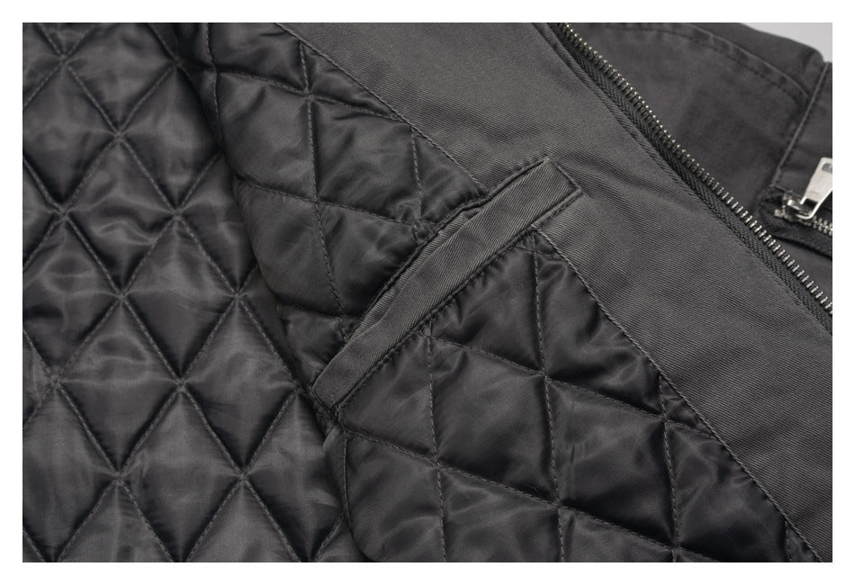 Close-up of a black jacket's diamond-quilted lining, interior pocket edge, and front zipper.