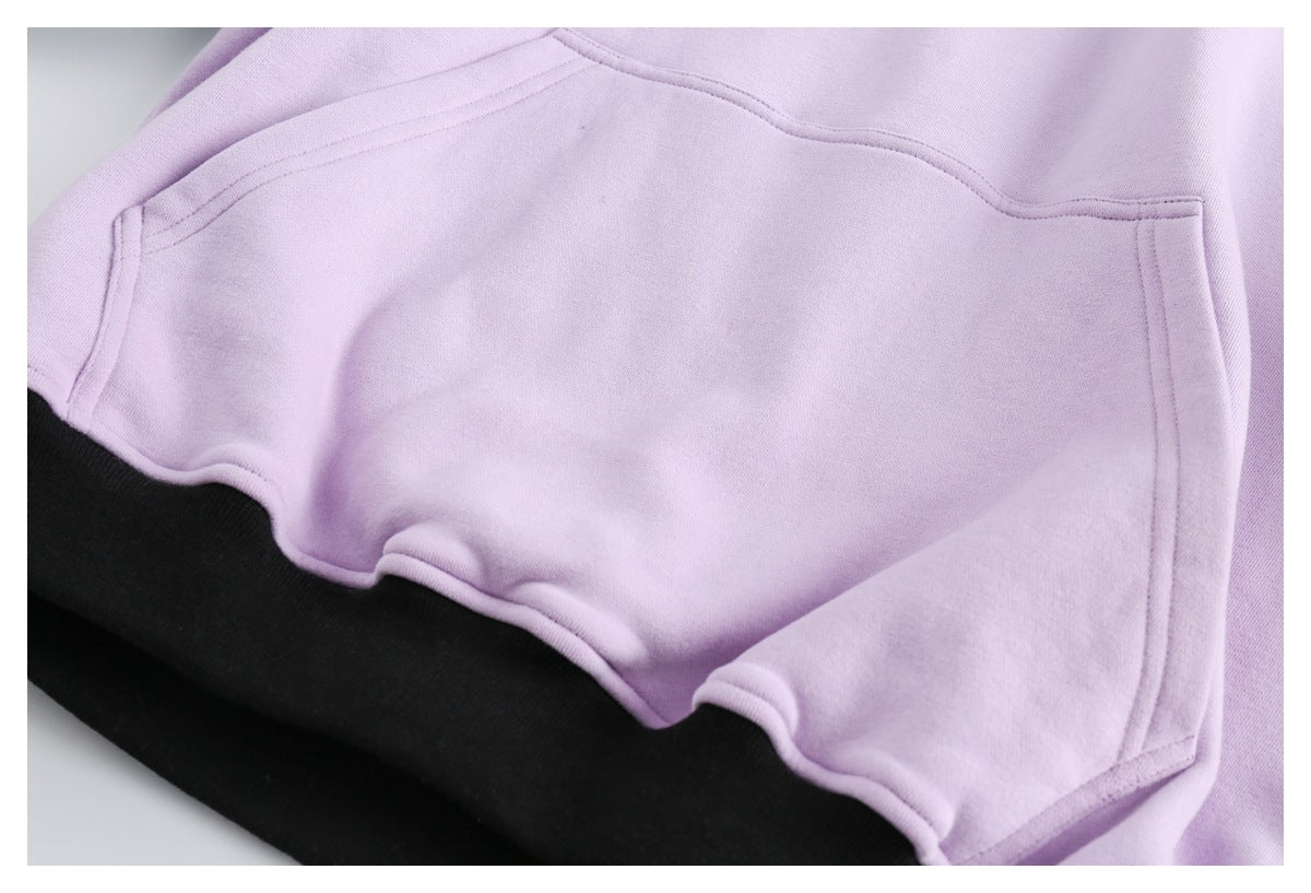 Close-up of a lilac hoodie kangaroo pocket above a black lower panel.