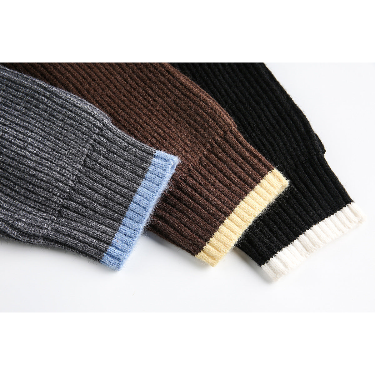Close-up of ribbed sweater cuffs in gray with blue trim, brown with cream trim, and black with white trim.