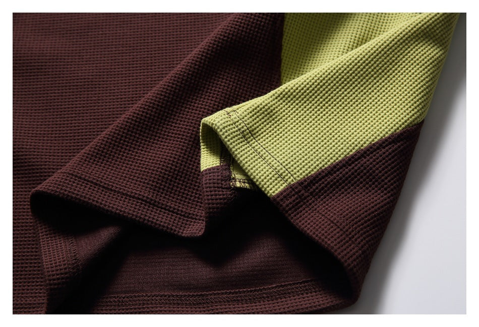 Close-up of burgundy and chartreuse waffle-knit fabric folded to show the contrasting panels and stitching.