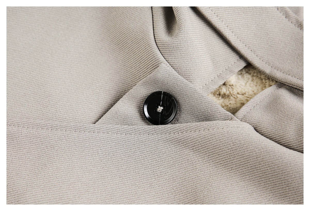 Close-up of a black button on the gray jacket beside a small section of cream lining.