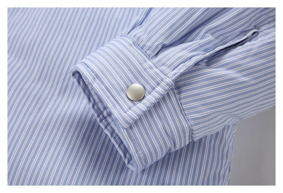 Close-up of a snap-fastened cuff on a pale blue and white striped shirt.