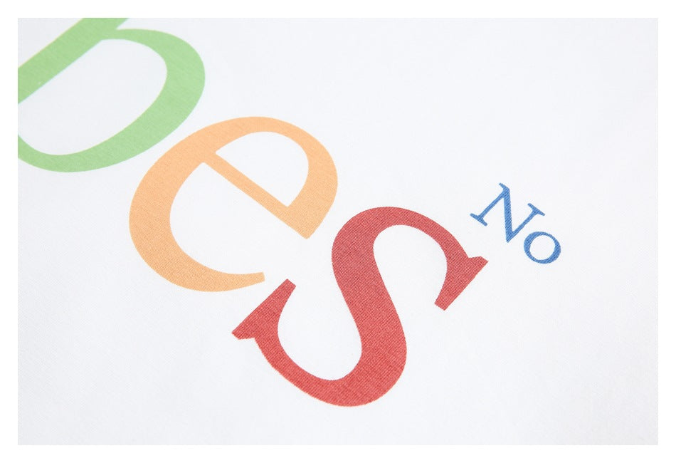 Close-up of the green, orange, and red lettering and blue “No” print on white fabric.