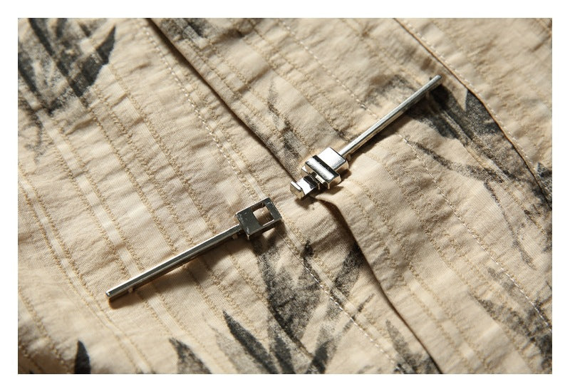 Close-up of the shirt's metal bar fastener and printed beige fabric.