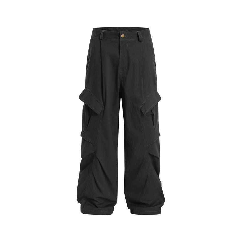 Front view of black wide-leg cargo trousers with oversized layered side pockets and a button waistband.