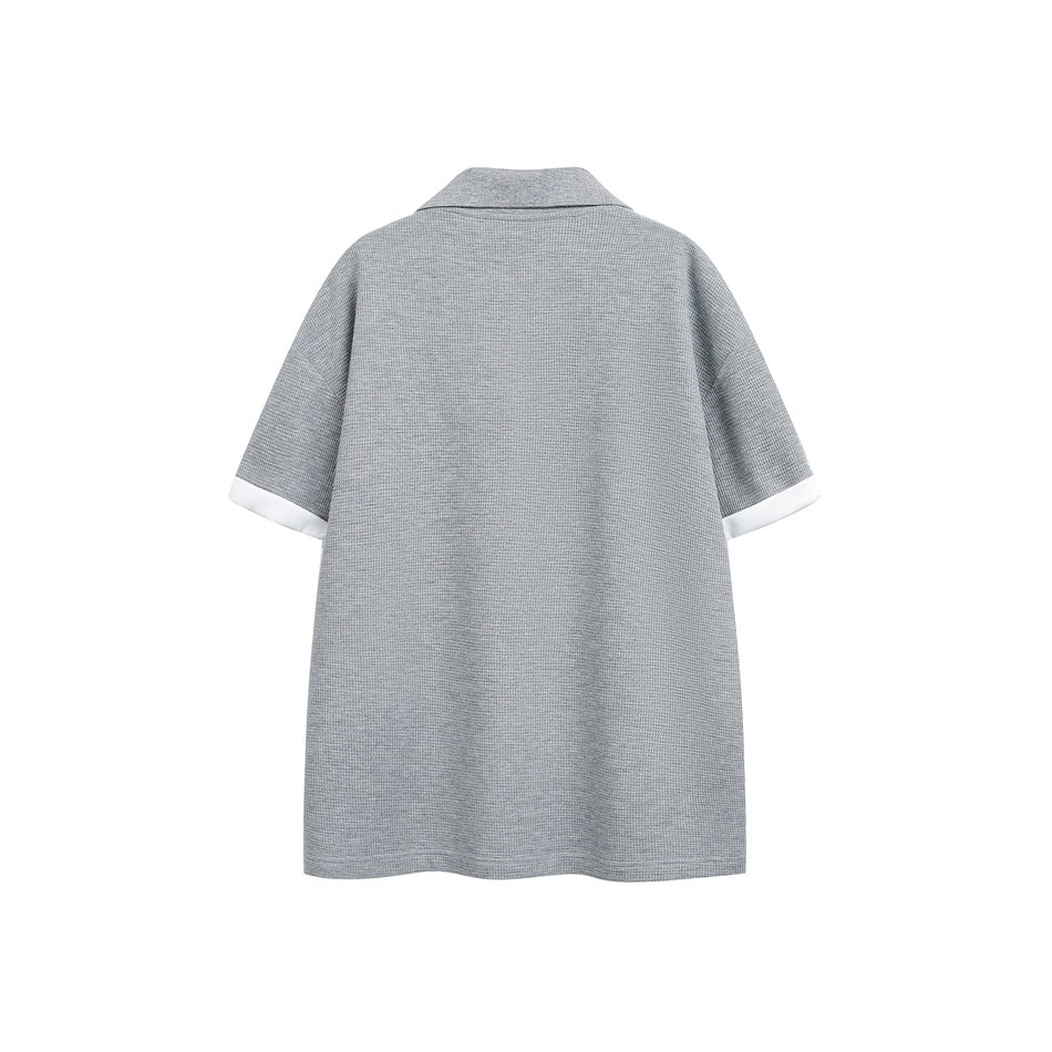Back view of a gray short-sleeve collared shirt with white sleeve cuffs.
