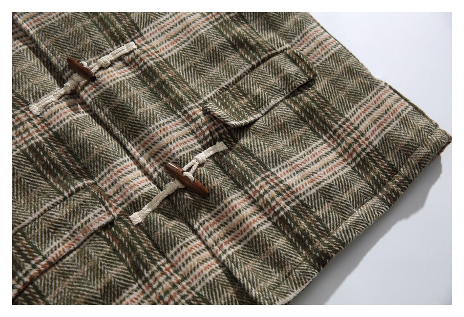 Close view of the plaid coat front with wooden toggles and a flap pocket.